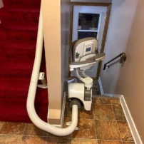 A Curved Stairlift Along The Inside Above A Red Carpet